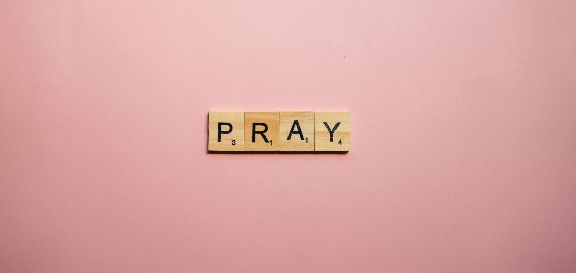 scrabble tiles that spell out prayer on a pink