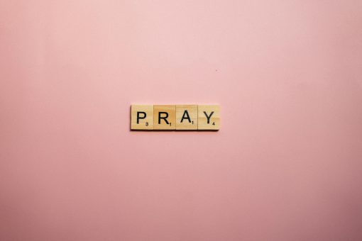 scrabble tiles that spell out prayer on a pink